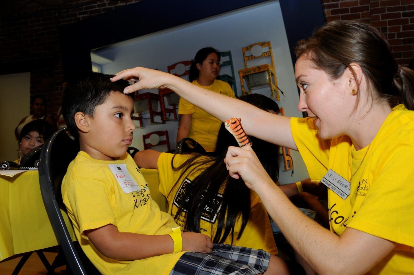 A volunteer from the New England College of Optometry checks out the eyes of an incoming kindergartener at the Countdown to Kindergarten Celebration at Boston Children’s Museum.
