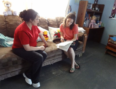 Ana and a mother talk about learning goals during a home visit.