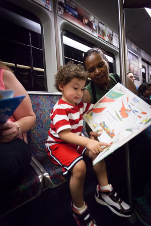  A grandmother helps her grandson identify the pictures in a children's book about transportation, while riding the "T" subway in Boston.