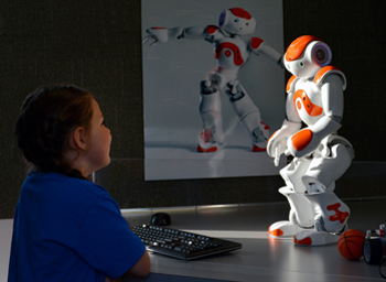 First-grader Bailey interacts with the humanoid robot, Leo, in the robotics station.